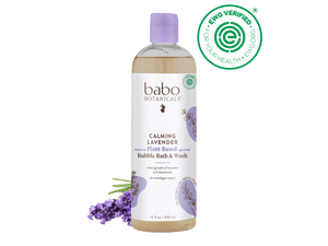 Babo Botanicals Calming Lavender Bubble Bath & Wash bottle with lavender flowers on a black background