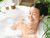 Woman relaxing in a bubble bath- Babo Botanicals