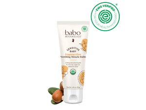 Babo Botanicals sensitive baby balm tube with ingredients on a black background