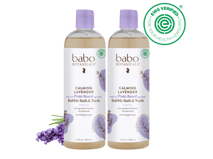 Two bottles of babo Botanicals Calming Lavender Bubble Bath & Wash on a black background with lavender flowers.