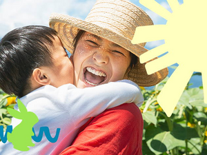 Women smiling holding boy kissing her on the cheek