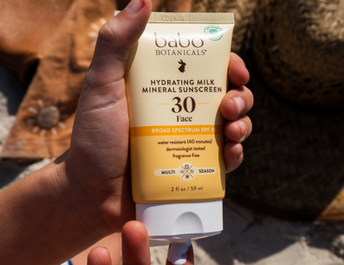 hand squeezing out spf onto finger at the beach
