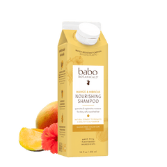A 16 fl oz carton of babo Botanicals Mango Barbado Sourced Nourishing Shampoo, shown on a white background with a mango and a pink flower graphic at the base.
