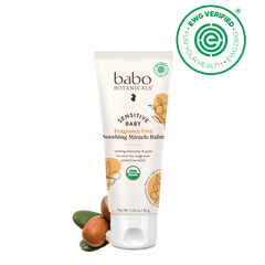 Babo Botanicals sensitive baby balm tube with ingredients on a black background